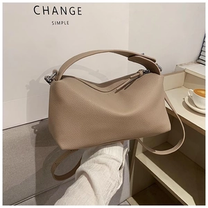 Détail du sac à main beige en cuir grainé avec texture souple et bandoulière réglable