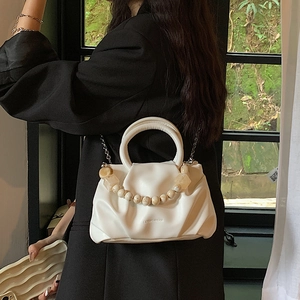 Weiße Cloud-Tasche mit Perlengriff und Metallkette an einem Model gezeigt