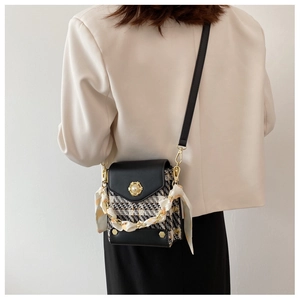Detail of tweed crossbody bag with pearl buckle and silk scarf wrapped chain strap