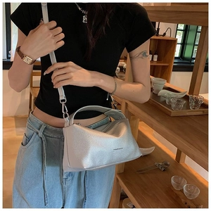 Détail du sac à main gris argenté en cuir litchi avec le logo Fashion & Bags sur l'avant