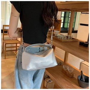 Gros plan détaillé d'un sac polochon en cuir litchi argenté avec détails gravés