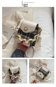 Detail of dark blue plaid tweed mini square bag with pearl buckle and scarf-wrapped chain