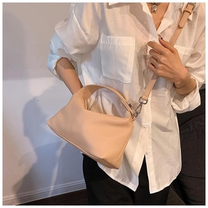 Détail d'un sac hobo en cuir texturé abricot avec bandoulière réglable et poignée large