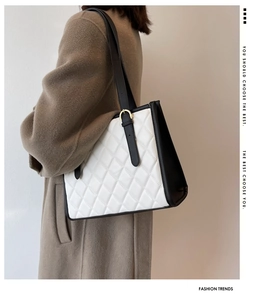 Quilted tote bag detail showing contrast panels and gold buckle on a brown coat model