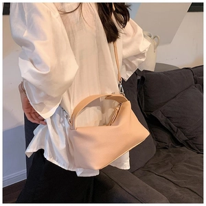 Détail du sac bandoulière en cuir grainé abricot avec des garnitures métalliques argentées