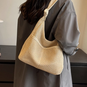 Large hand-woven straw hobo shoulder bag with cream leather trim and decorative strap knot