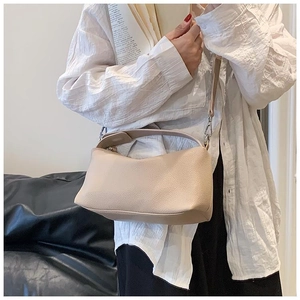 Détail du sac hobo montrant la bandoulière réglable et le grain de cuir synthétique beige