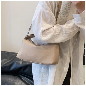 Gros plan détaillé du cuir à motif litchi et du design plissé en V sur un sac à main