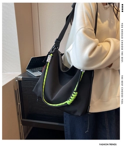 Detail showing high-density nylon fabric and fluorescent green woven rope on a black bag