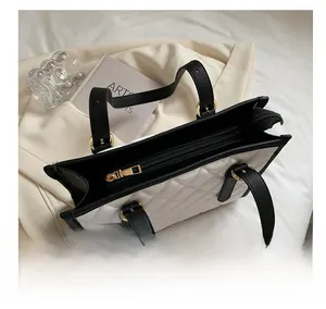 Top view detail of high-capacity quilted tote bag with smooth metal zipper and contrast trim