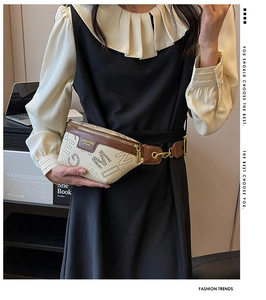 Detail van premium crossbody borsttas met beige letterprint en bruine brede riem