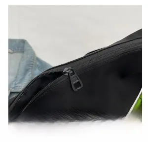 Detail of smooth black metal zipper on nylon tote bag with green braided rope strap