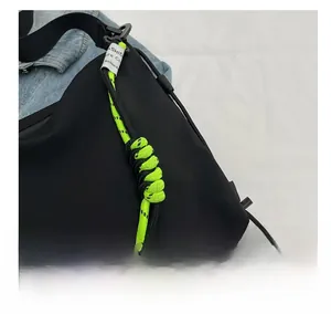 Close-up of nylon tote with neon green woven cord and white woven label on blue denim
