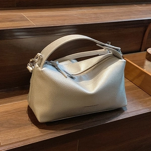 Sac à main polochon beige en cuir grainé de grande capacité sur un escalier