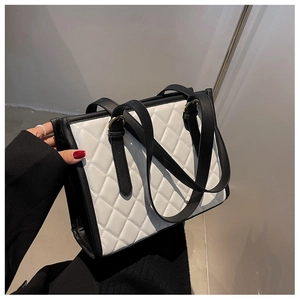 Detailed close-up of quilted contrast tote bag with elegant gold-tone metal hardware