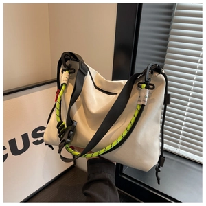 Detail of white nylon tote featuring contrast neon yellow drawstring and black wide strap