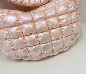 Detaillierte Nahaufnahme der sauberen Nähte und der gesteppten Metallic-Textur der Tasche