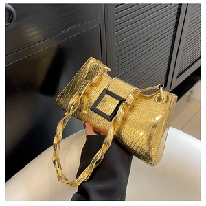 Detail van de gouden handtas met krokodillenstructuur en matte zwarte vierkante gesp