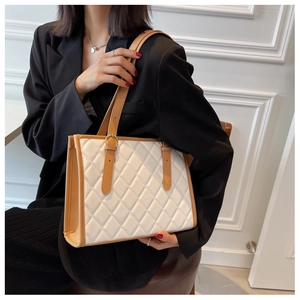 Quilted tote bag with white leather, brown contrast straps, and gold buckle detail