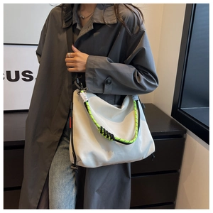 Close-up of white nylon tote bag featuring vibrant neon green and black rope strap detail
