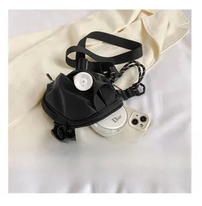 Detail view of black nylon crossbody bag interior capacity with phone and cosmetics