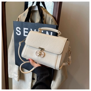 Détail du sac en cuir texturé blanc cassé avec fermoir doré et poignée chic