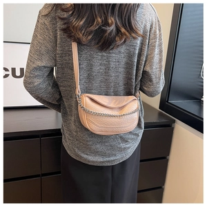 Vista detallada de un bolso silla de cuero granulado beige con cadena y correa de plata