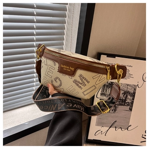 Detail van een chique crossbody borsttas van crème kiezelleder met bruine leren bies