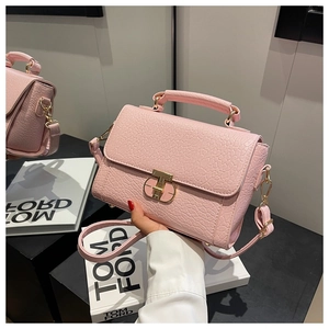 Vue détaillée du petit sac carré rose à motif crocodile avec fermoir rotatif doré
