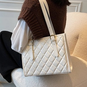 White quilted tote bag with gold buckles and minimalist design for casual daily use