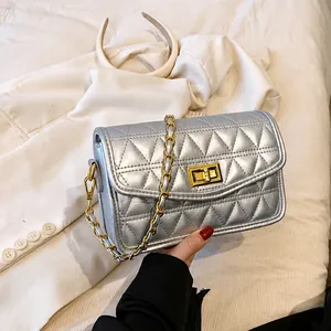 Vue détaillée d'un sac argenté matelassé avec fermoir doré et bandoulière en chaîne