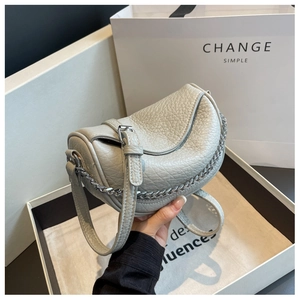 Detalle del bolso de silla de montar en cuero granulado gris con ribete de cadena plata