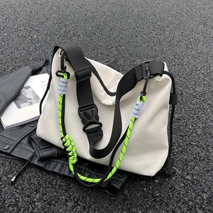 White nylon large capacity messenger bag with black strap and neon green accents