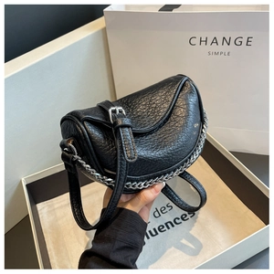 Detalle del bolso de silla en cuero granulado negro con decoración de cadena plateada