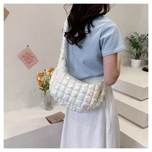 Rückansicht eines Models mit einer holografischen gesteppten Puffy-Schultertasche im Studio
