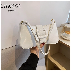 Detail of white crocodile pattern baguette bag with large square buckle and wide strap