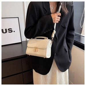 Vue détaillée d'un sac bandoulière en cuir blanc avec fermoir doré sur un mannequin femme