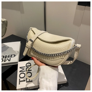 Detalle del bolso de hombro beige en cuero granulado con cadena metálica plateada