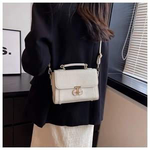 Détail du sac à main blanc cassé avec texture grainée, fermoir doré et bandoulière fine