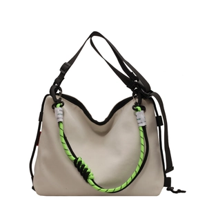 Large beige nylon tote bag with neon green cords and adjustable black shoulder strap