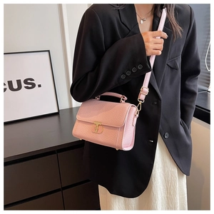 Détail du sac bandoulière rose à motif croco avec fermoir métallique en T doré
