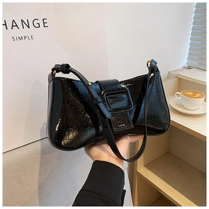 Detail of black crocodile texture underarm bag with square buckle and glossy finish