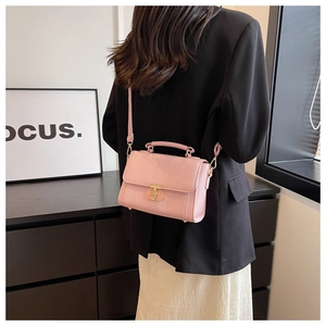 Vue détaillée du petit sac carré rose en cuir grainé avec fermoir rotatif doré
