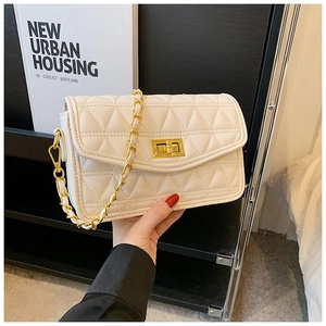 Détail du sac bandoulière matelassé blanc crème avec chaîne dorée et fermoir rotatif