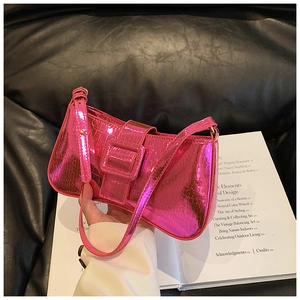 Close-up of pink crocodile pattern armpit bag with metallic finish and large buckle detail