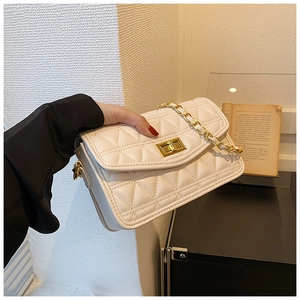 Détail du sac bandoulière matelassé blanc avec chaîne dorée et fermoir métallique