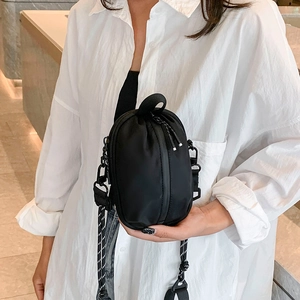 Minimalist black quilted crossbody bag with stylish striped woven strap for women