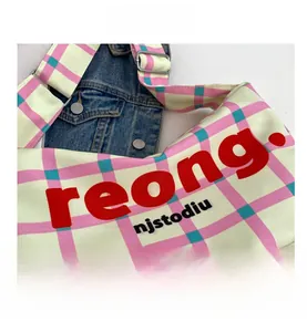Detail of canvas crossbody bag showing two-tone plaid pattern and metal adjustment buckle