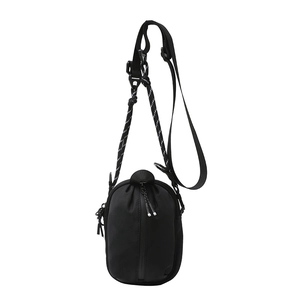 Minimalist black nylon crossbody bag with outdoor-style ropes on a white background