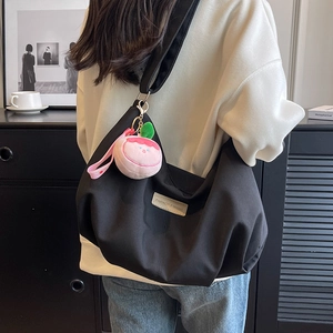 Black nylon hobo bag with peach charm, large capacity messenger style for casual wear